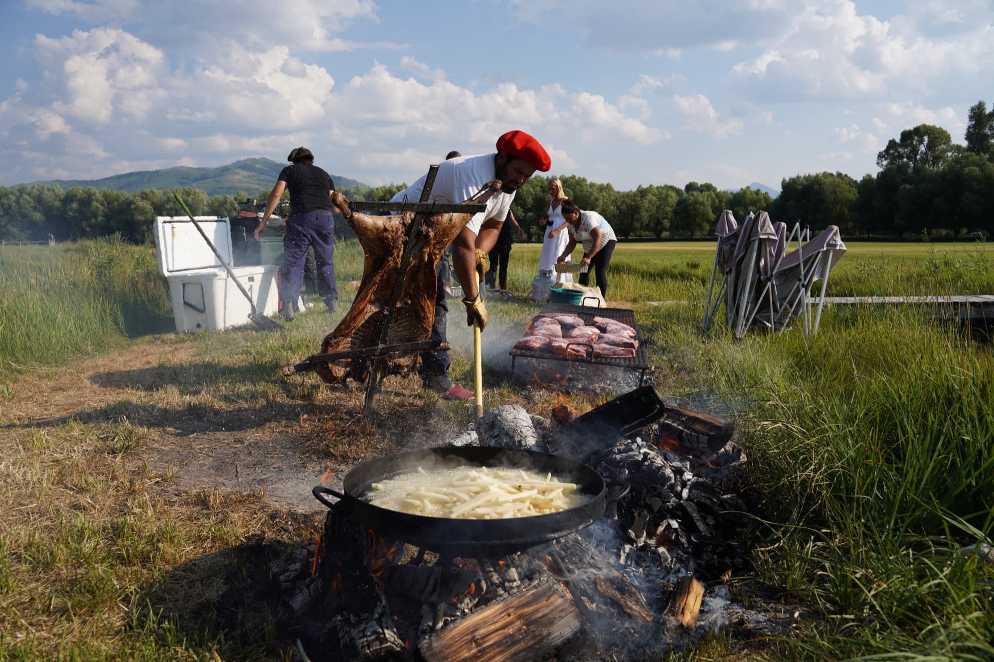 A whole asado cooked a la cruz over an open fire in an open field